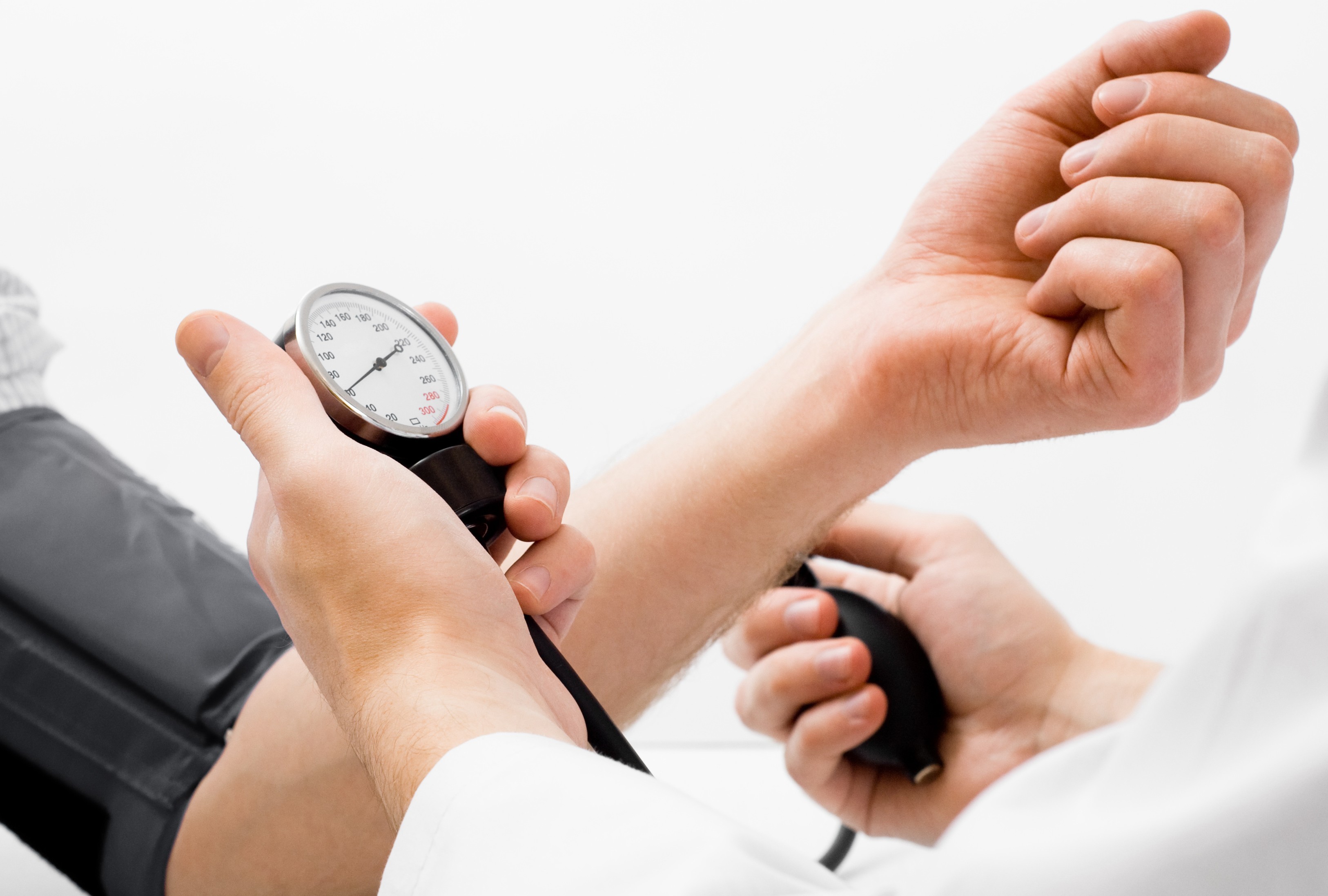 Doctor measuring blood pressure - studio shot on white background